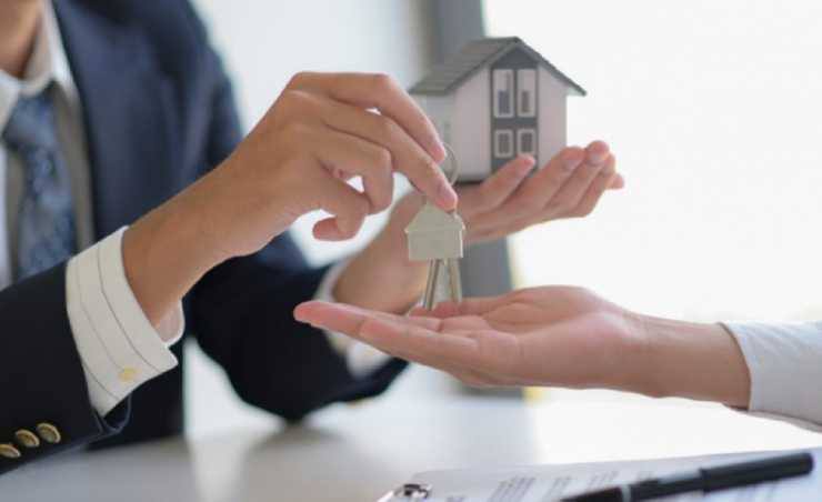 a person receiving a house key after completing the purchasing process